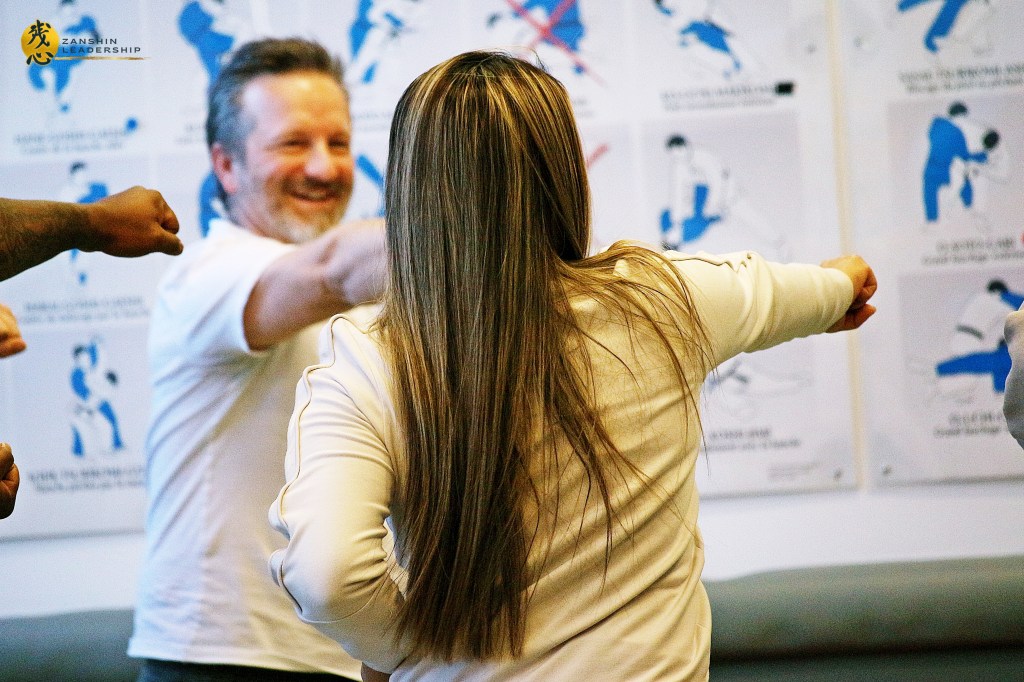 A group of professionals practicing team-building exercises led by Matthaeus Bauernberger, inspired by martial arts principles.