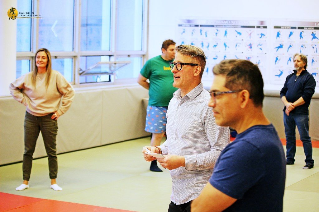 Workshop participants practicing paired martial arts techniques under Matthaeus Bauernberger’s guidance, embodying the philosophy of "Maai" (distance) in professional relationships.